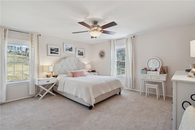 bedroom featuring light carpet, baseboards, and ceiling fan