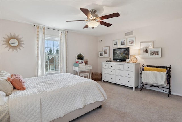 bedroom with visible vents, light carpet, and ceiling fan