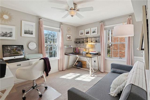 carpeted office featuring baseboards and ceiling fan