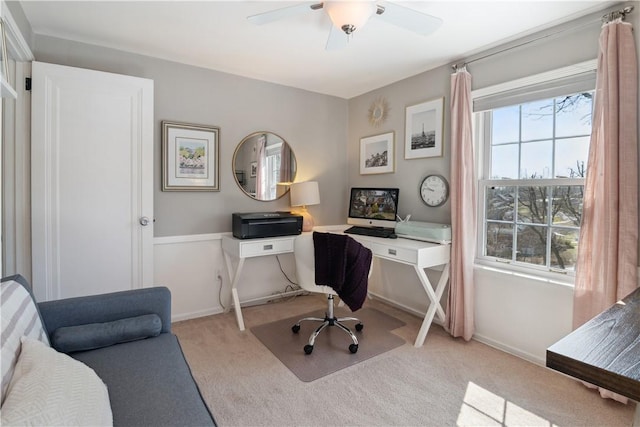 carpeted office with a ceiling fan and baseboards