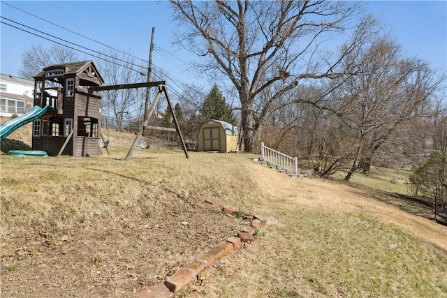 view of yard with an outdoor structure, a playground, and a shed