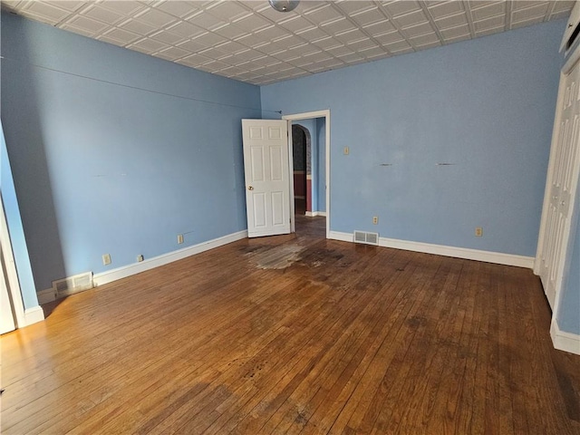 unfurnished bedroom with visible vents, an ornate ceiling, baseboards, and hardwood / wood-style flooring