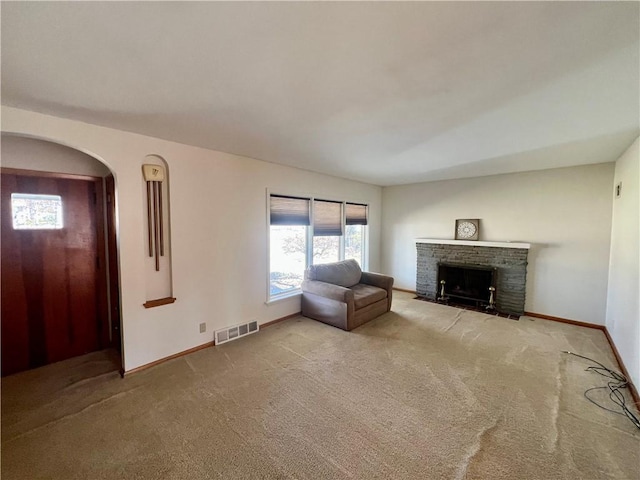 unfurnished living room with visible vents, carpet flooring, a brick fireplace, and baseboards