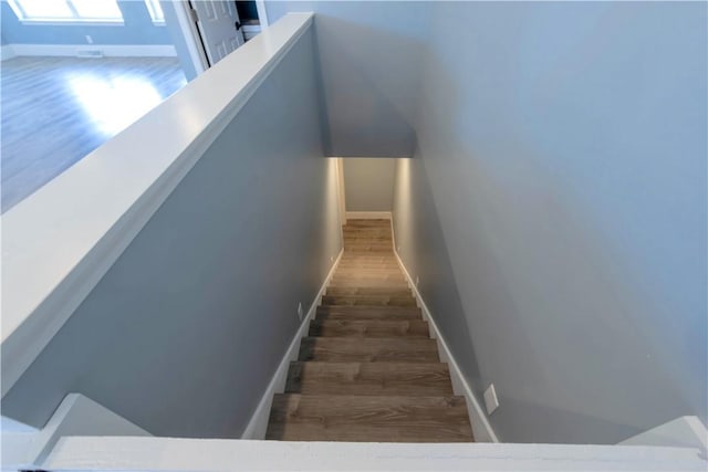 stairs featuring wood finished floors and baseboards