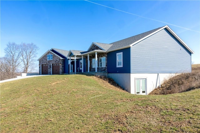 view of front of property with a garage, covered porch, driveway, and a front yard