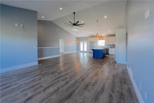 unfurnished living room featuring visible vents, baseboards, ceiling fan, dark wood finished floors, and high vaulted ceiling