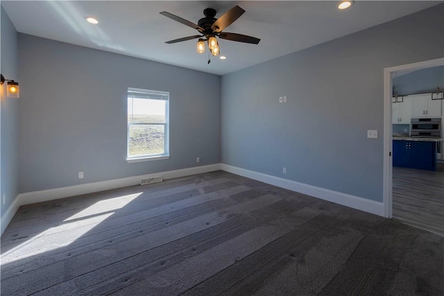 unfurnished room with visible vents, baseboards, recessed lighting, a ceiling fan, and dark wood-style flooring