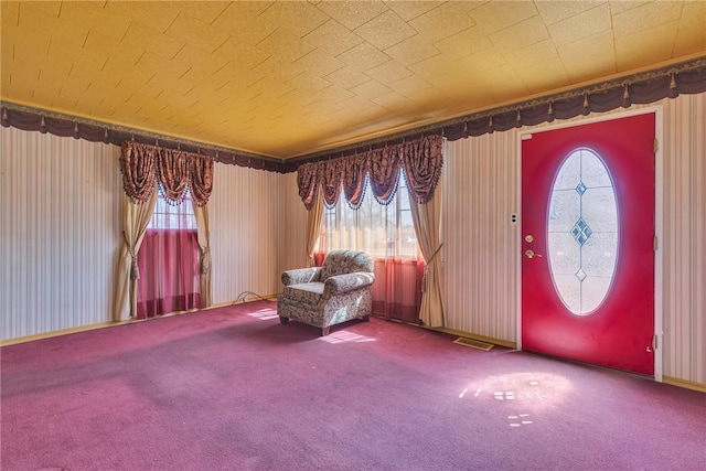 foyer entrance with visible vents and carpet floors