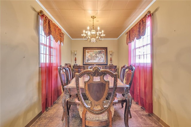 dining area featuring baseboards, an inviting chandelier, and crown molding