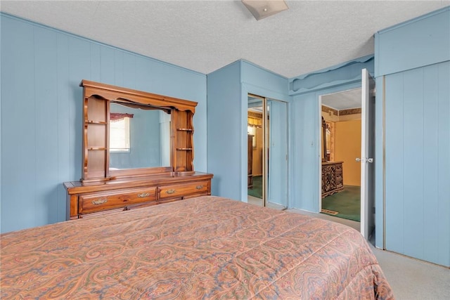 carpeted bedroom featuring multiple closets and a textured ceiling