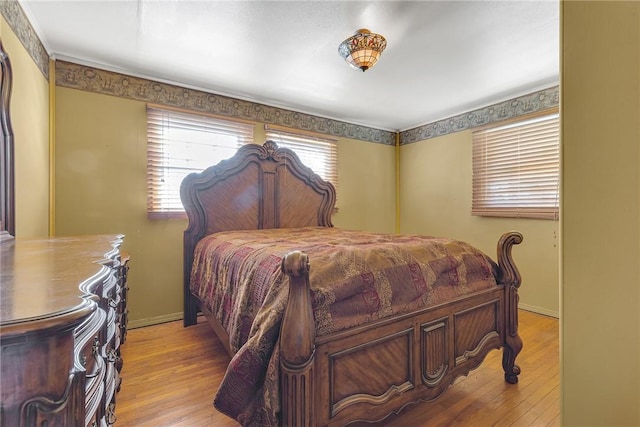 bedroom with baseboards and wood finished floors