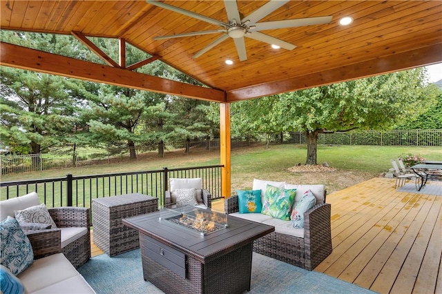 wooden terrace with an outdoor living space with a fire pit, a yard, a fenced backyard, and a ceiling fan