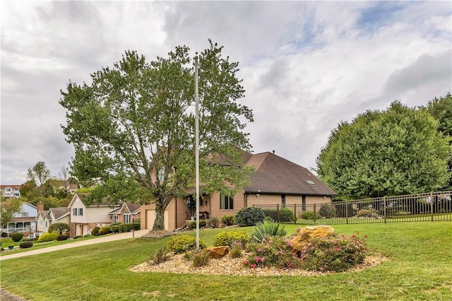 view of front of property with concrete driveway, a garage, fence, and a front lawn