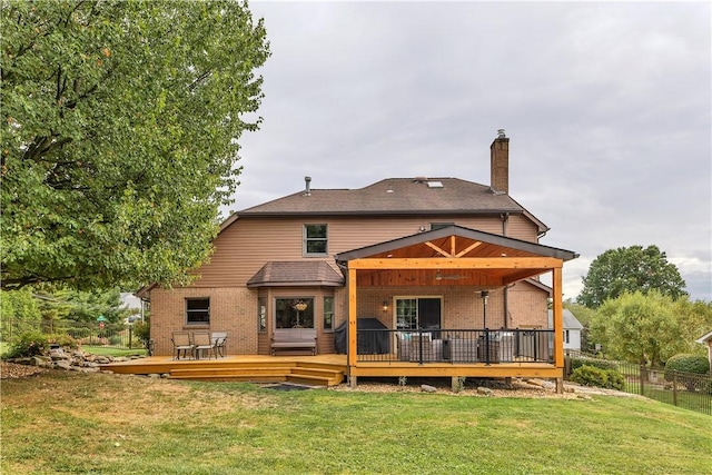 back of house featuring fence, a wooden deck, a yard, a chimney, and brick siding