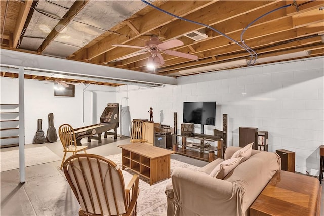 below grade area with stairway, ceiling fan, and concrete block wall