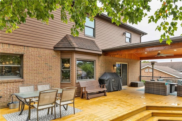 wooden terrace featuring area for grilling, outdoor dining area, and a ceiling fan