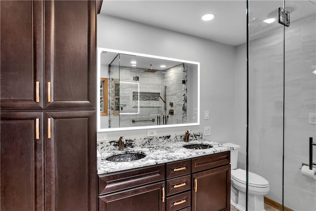 bathroom featuring a sink, toilet, double vanity, and a shower stall