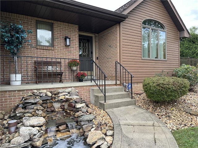 doorway to property featuring brick siding