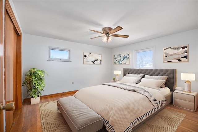 bedroom with a closet, baseboards, light wood-style flooring, and a ceiling fan