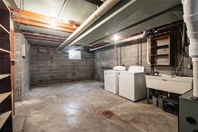 basement with a sink and washer and clothes dryer