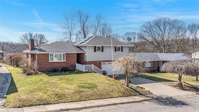 split level home featuring driveway, brick siding, an attached garage, and a front lawn