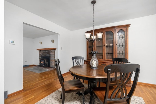 dining space featuring a notable chandelier, light wood-style flooring, visible vents, and baseboards