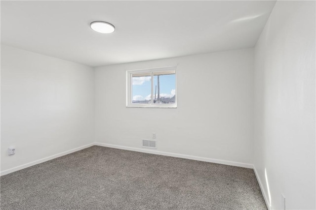 spare room featuring visible vents, carpet, and baseboards