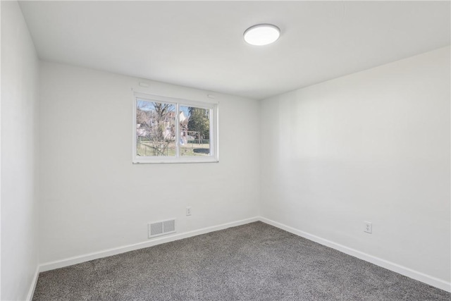 spare room with carpet flooring, baseboards, and visible vents