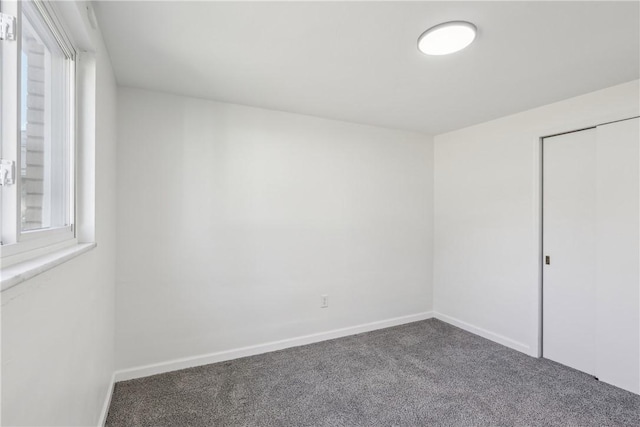 empty room featuring baseboards and carpet floors