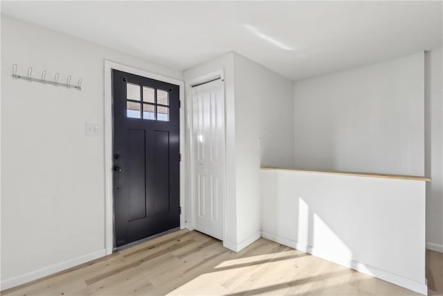 entrance foyer with baseboards and light wood finished floors