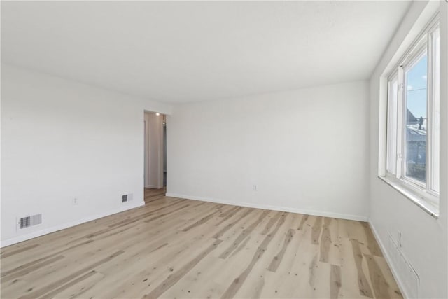 spare room featuring baseboards, visible vents, and light wood finished floors