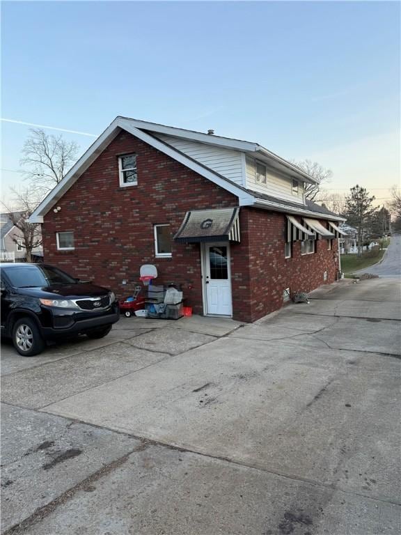 view of home's exterior with brick siding and driveway