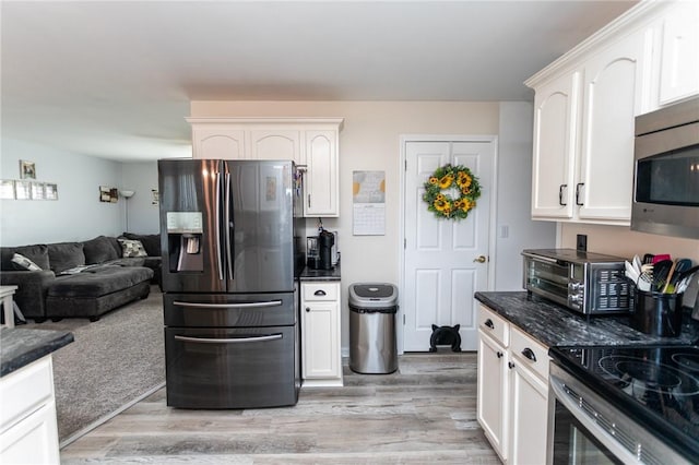 kitchen with a toaster, light wood-style flooring, appliances with stainless steel finishes, and white cabinetry