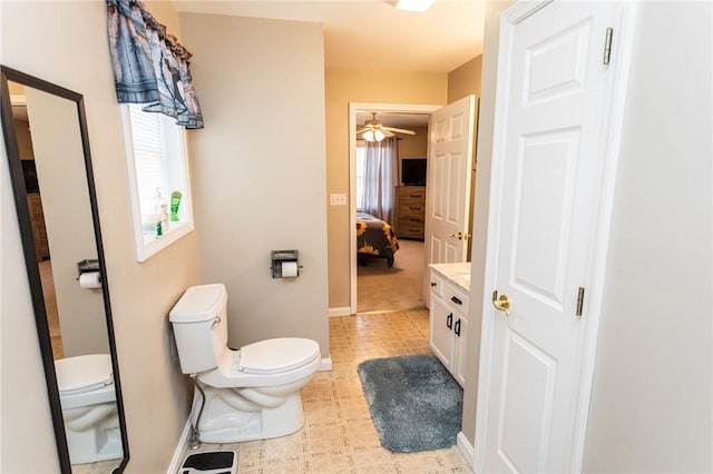 ensuite bathroom featuring tile patterned floors, ceiling fan, toilet, and baseboards