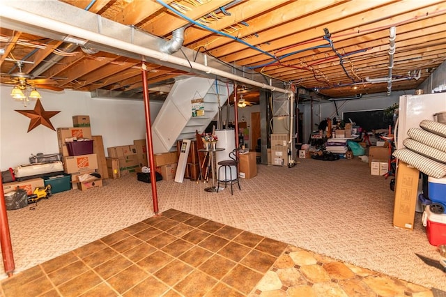 unfinished basement with heating unit, gas water heater, and carpet floors