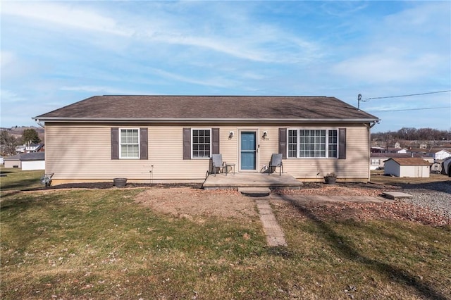 single story home with a shingled roof, a front lawn, and a patio