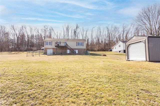 rear view of property with an outbuilding, a yard, and fence