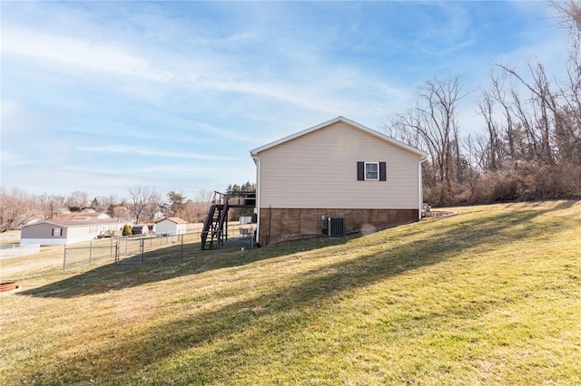 view of side of home featuring stairs, cooling unit, a lawn, and fence