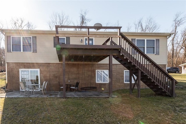 back of property with brick siding, a lawn, stairs, and a patio