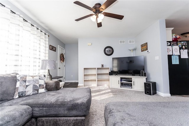 carpeted living room featuring baseboards, visible vents, and ceiling fan