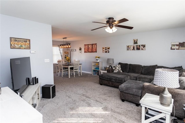 carpeted living room with ceiling fan with notable chandelier