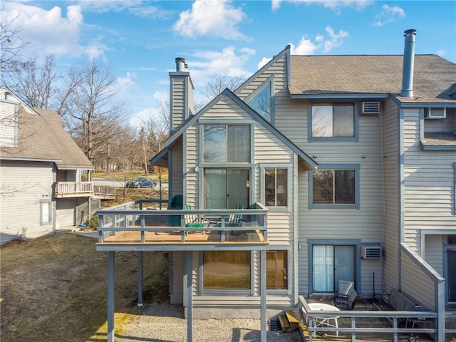 back of house with a chimney and a deck