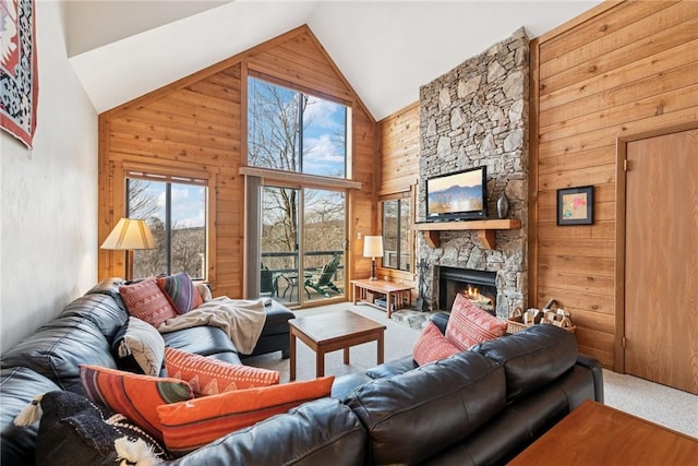 carpeted living area with a fireplace, wood walls, and high vaulted ceiling