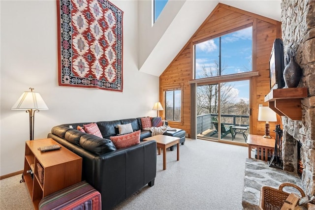 carpeted living area featuring high vaulted ceiling, wood walls, and a fireplace