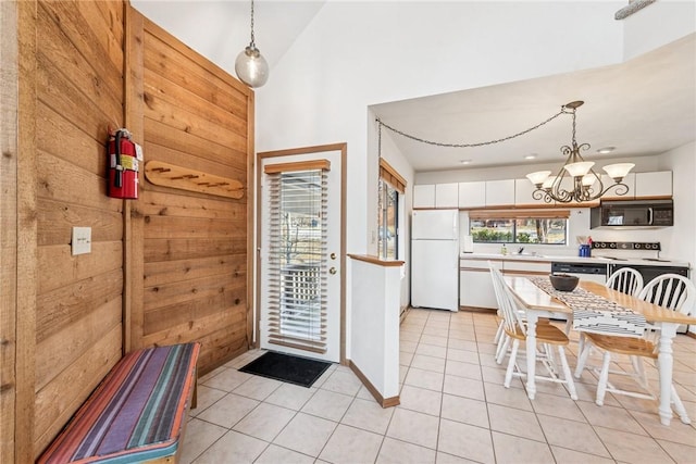 kitchen featuring a sink, white appliances, light tile patterned flooring, light countertops, and a chandelier