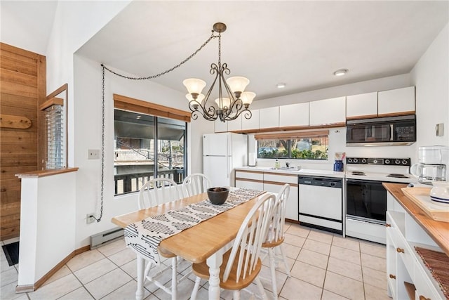 kitchen featuring light countertops, light tile patterned floors, a notable chandelier, white appliances, and white cabinetry