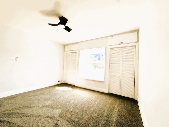 unfurnished bedroom with a ceiling fan, baseboards, and carpet floors