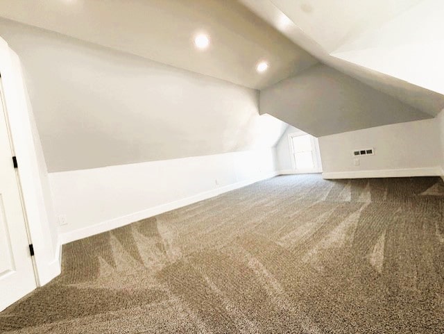 bonus room with baseboards, lofted ceiling, and carpet floors