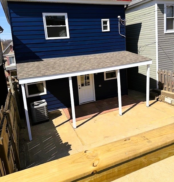 back of house featuring a patio area, central air condition unit, a shingled roof, and fence