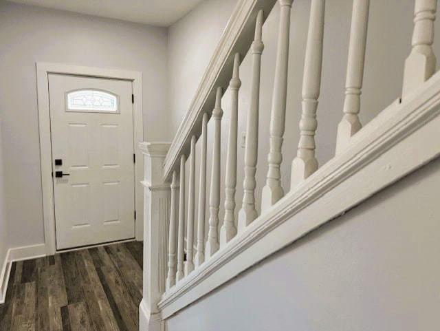 entryway featuring dark wood-type flooring and stairs